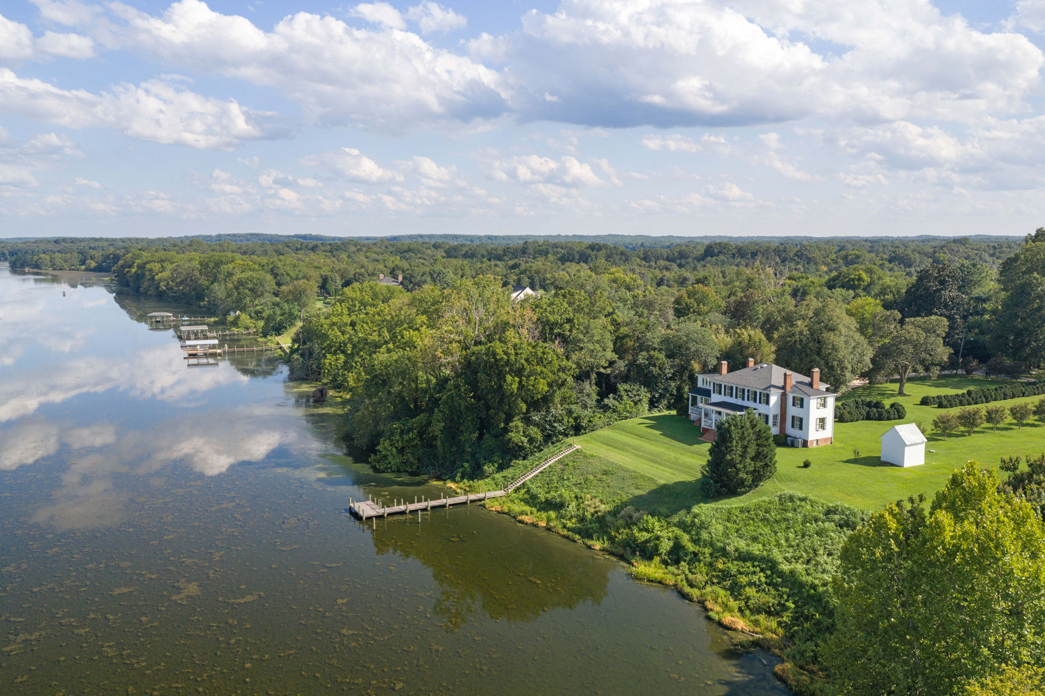 Aerial front approach view of a riverfront estate
