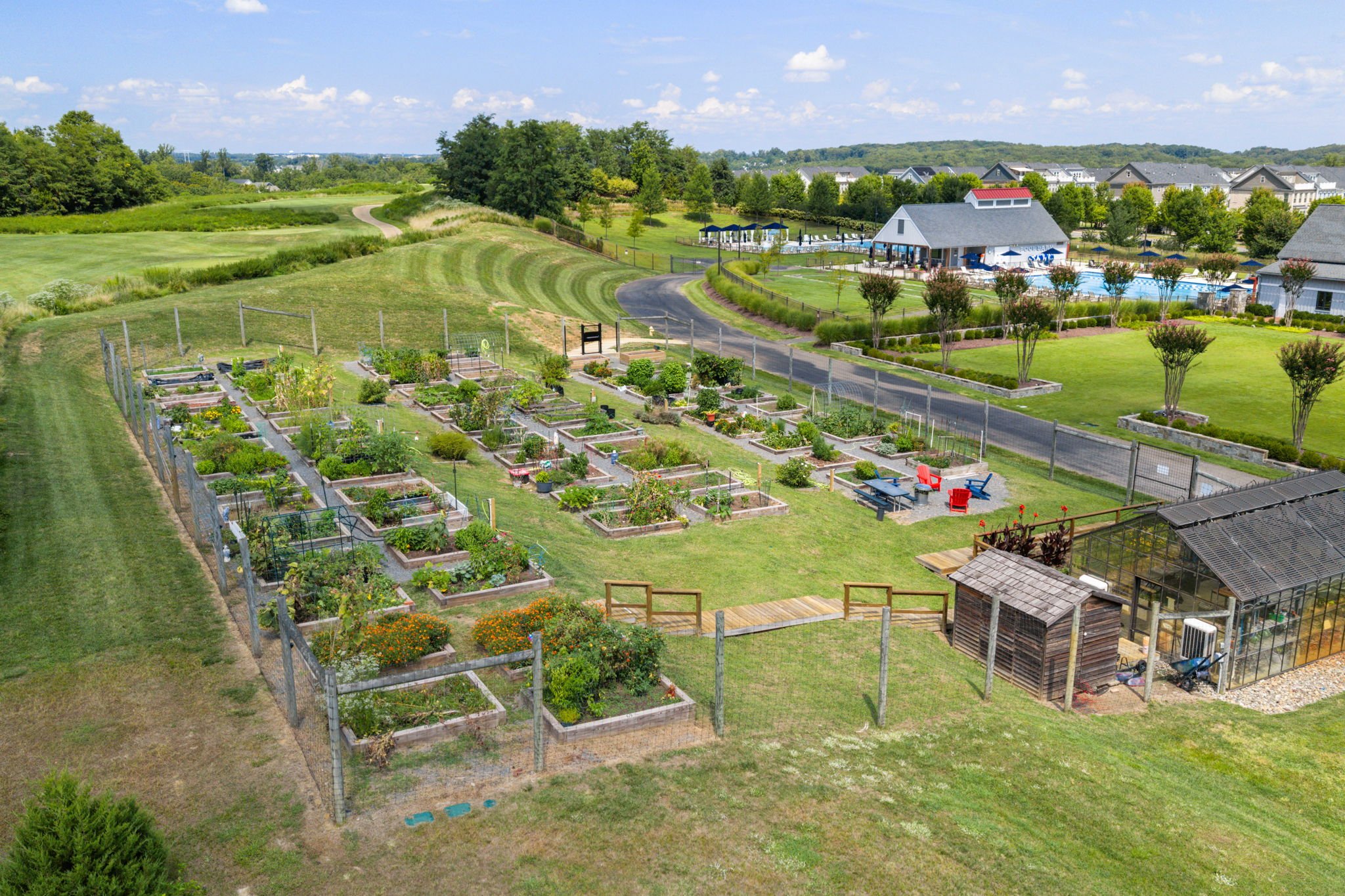 Aerial view of tennis and pickleball courts near a community clubhouse