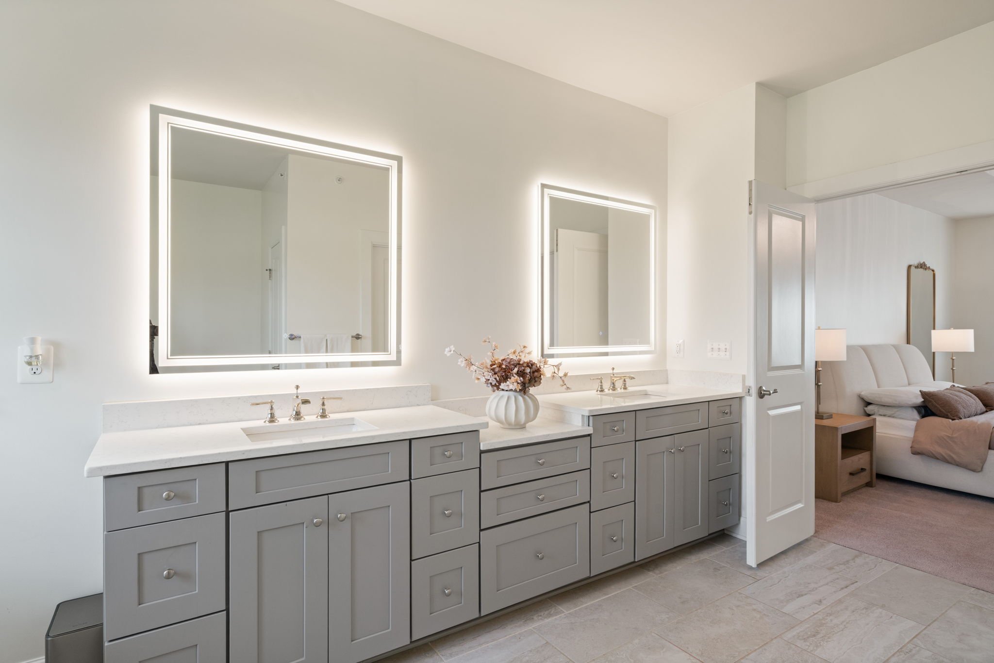 Bathroom with double vanity and backlit mirrors