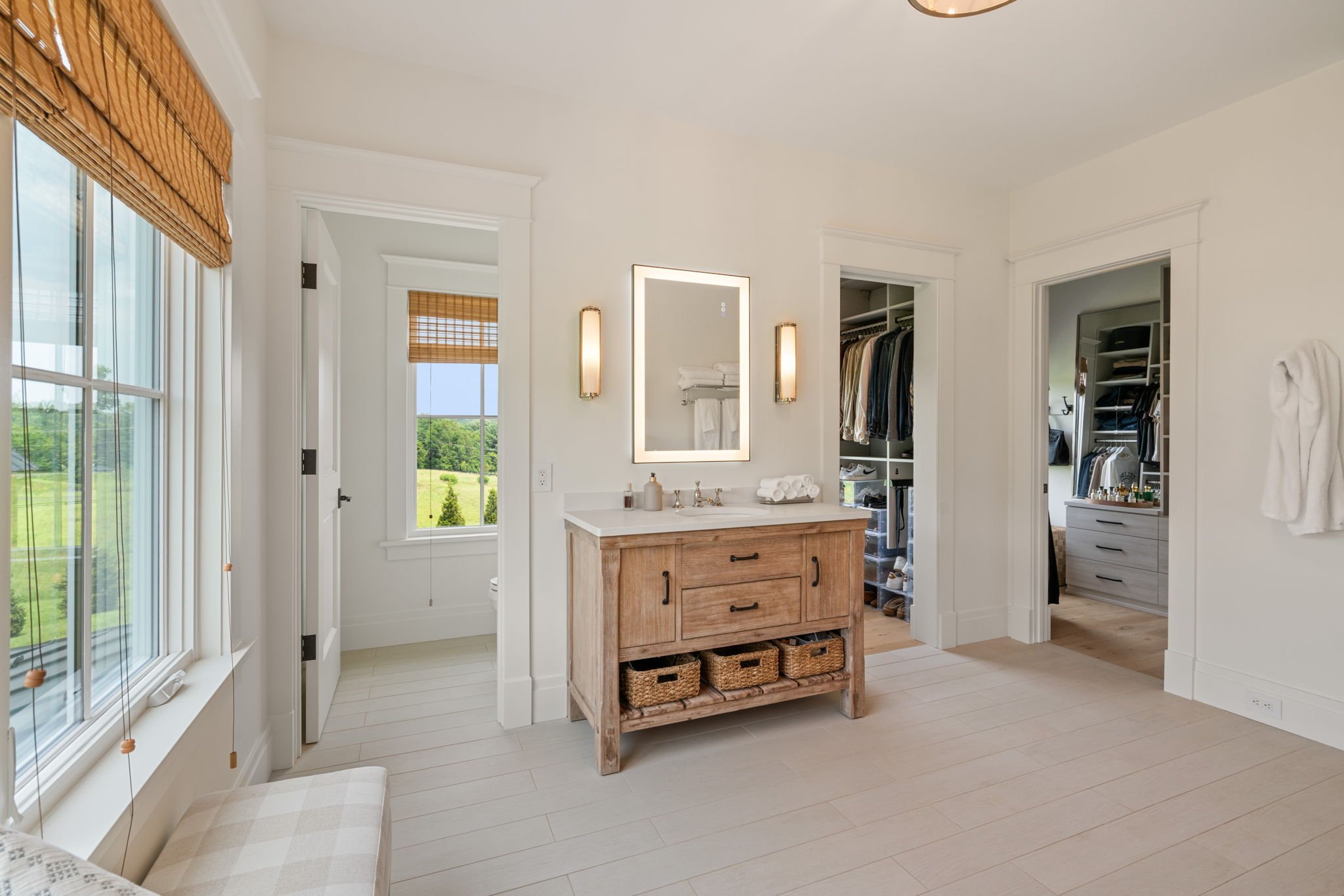 Dressing area with vanity between his and hers walk-in closets