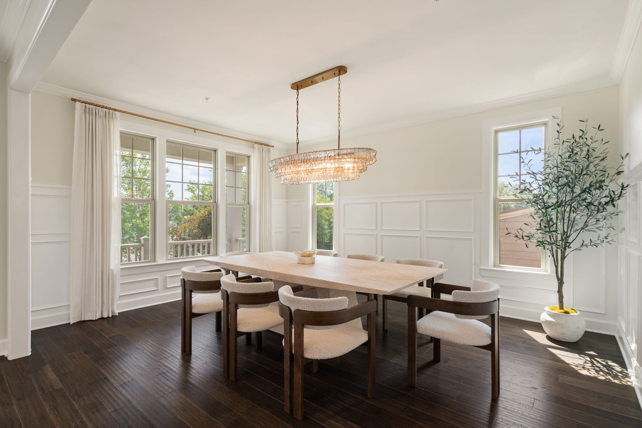Formal dining room with rectangular table, crystal chandelier, and wainscoting