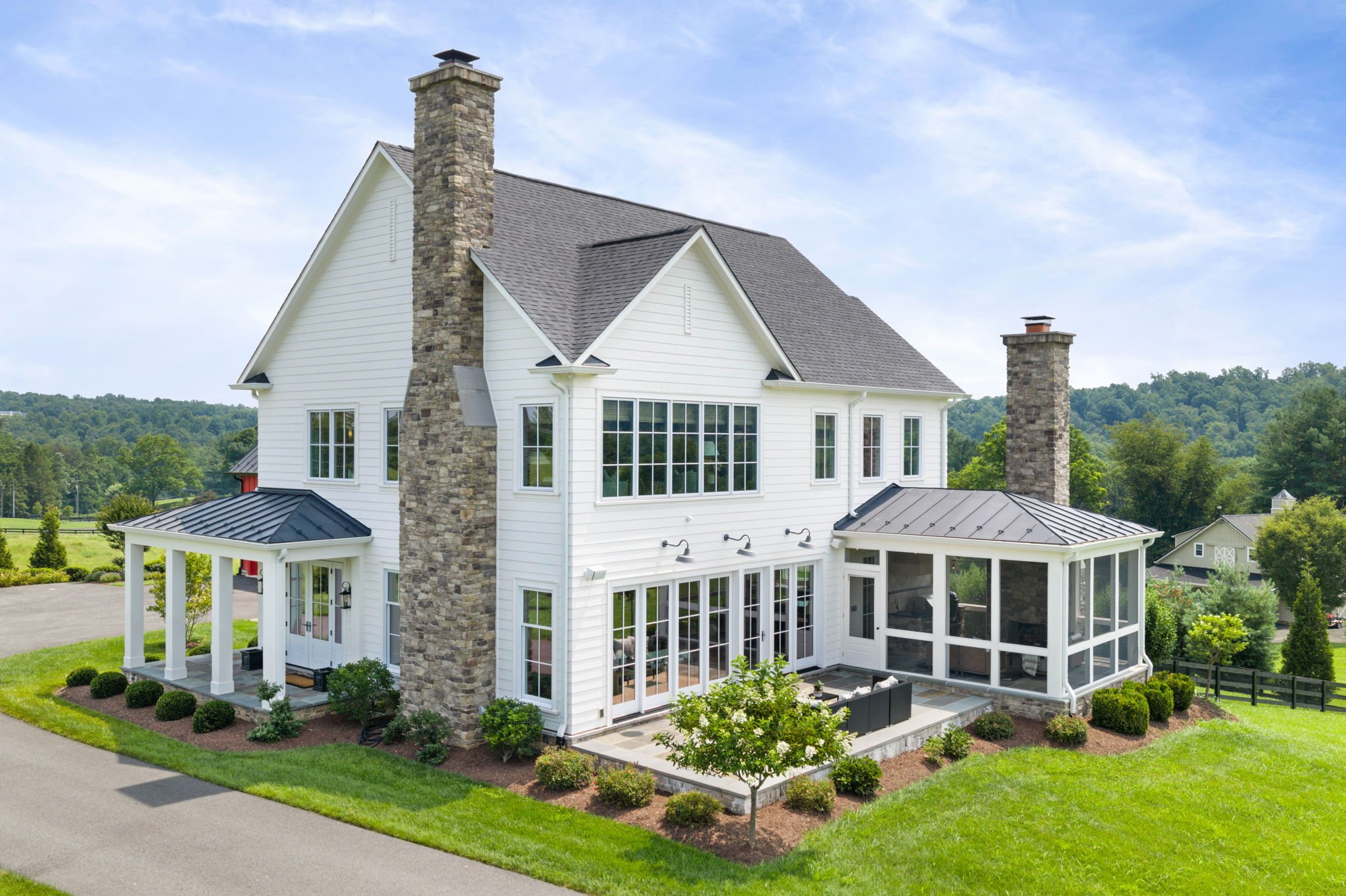Aerial view of a white farmhouse's rear exterior, alternate angle