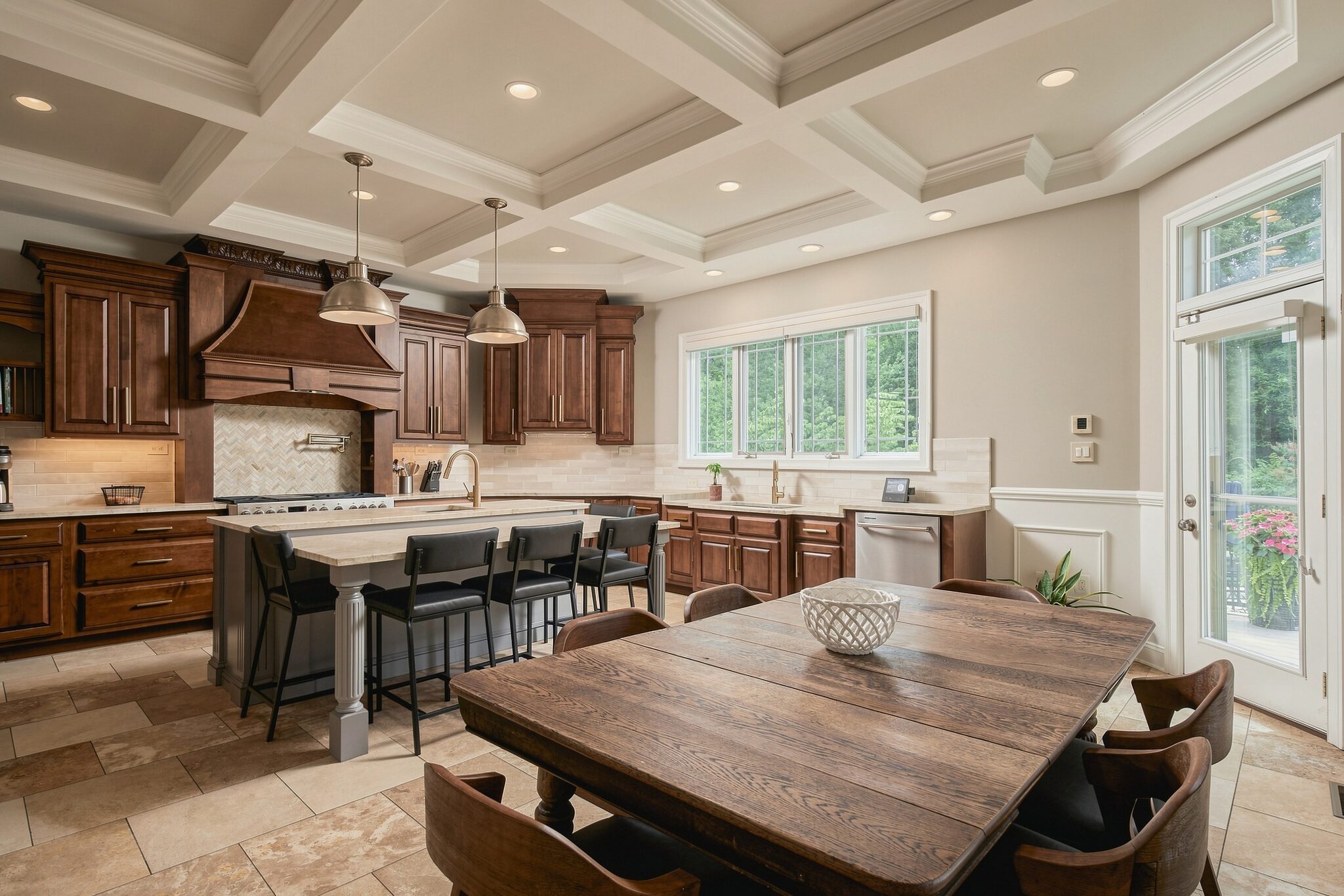 Eat-in kitchen with wood cabinetry, farmhouse table, and French doors to the deck