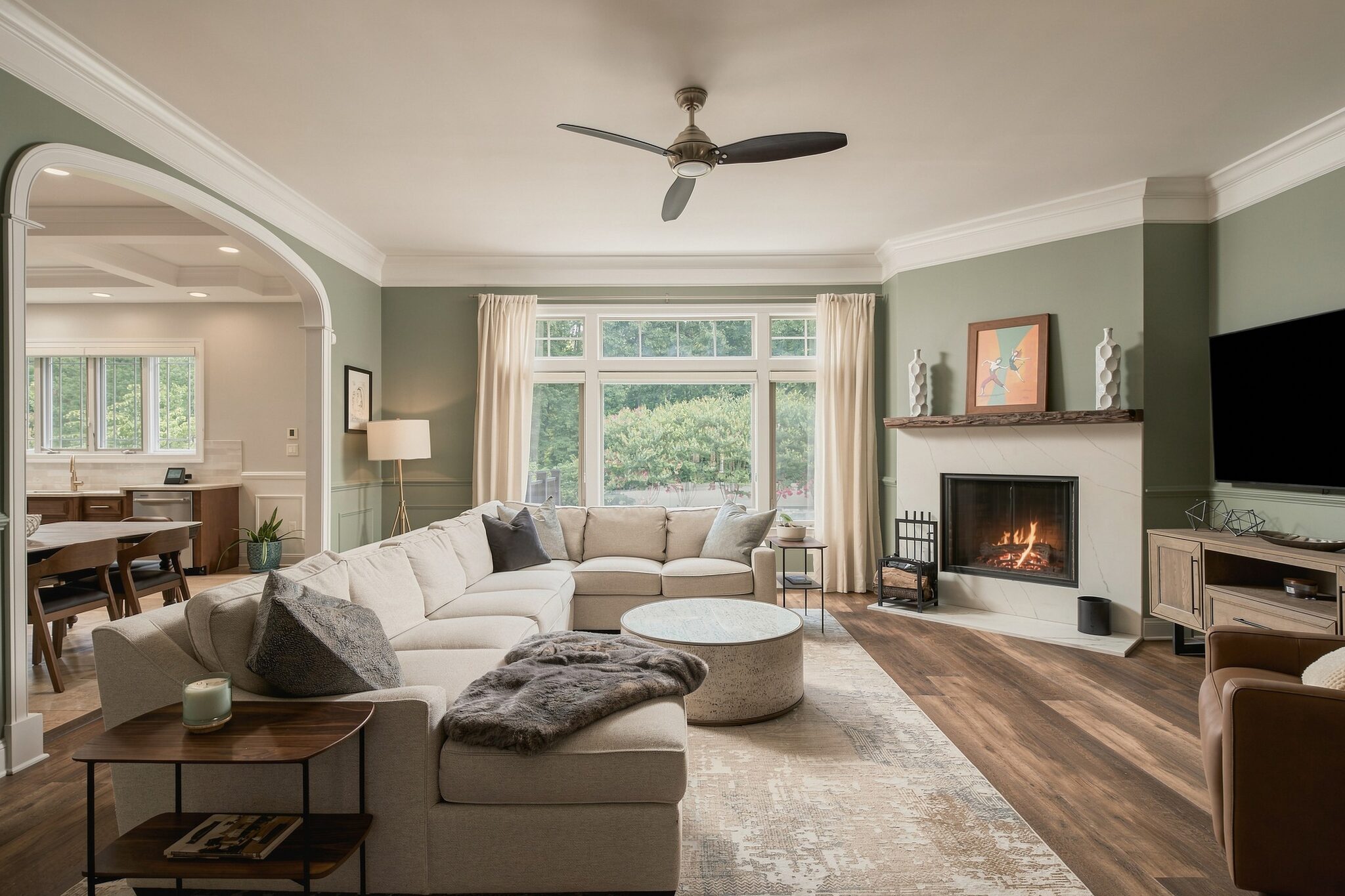 Living room sectional and coffee table opening onto the kitchen and dining area